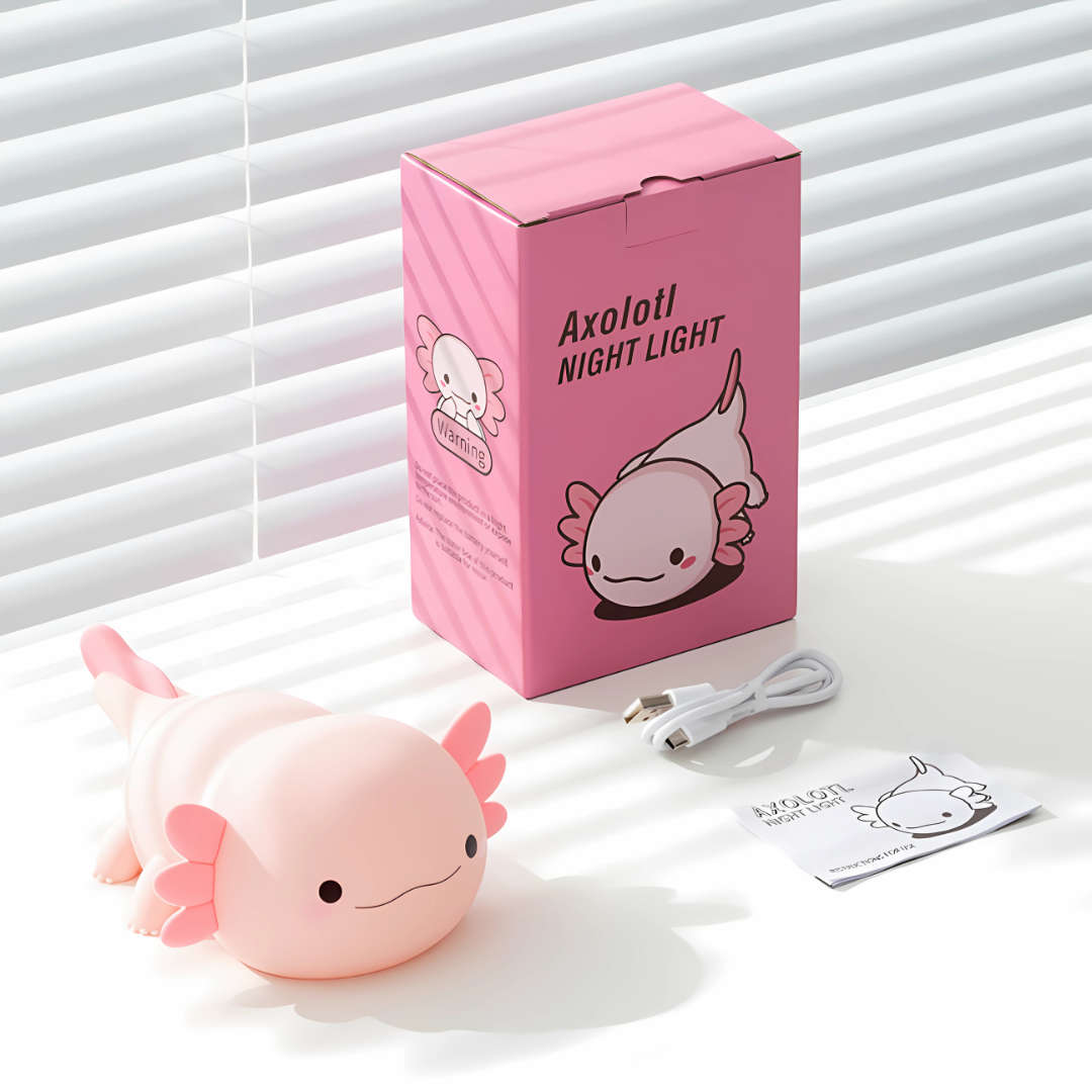 Pink axolotl night light with packaging and USB cable on a white surface.