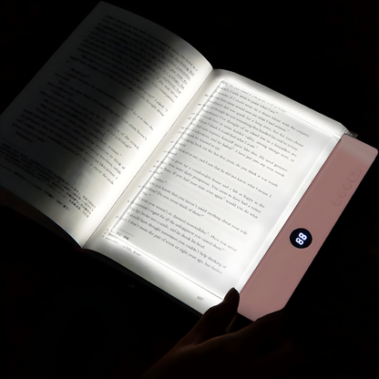 Open book illuminated by a portable light device in a dark setting